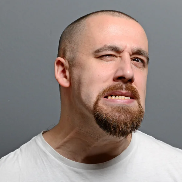 Portrait of a man making funny face against gray background