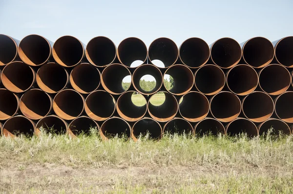 Closeup of a pile of large and rusting steel pipes