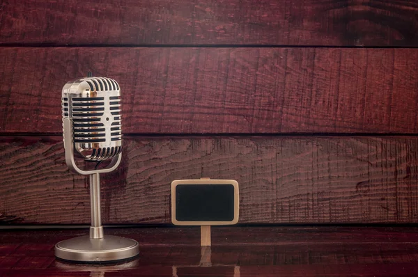 Vintage microphone on old wooden background
