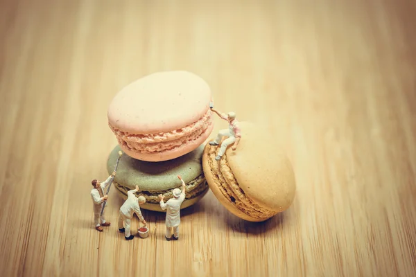 Group of miniature painters coloring macaroon. Color tone tuned.
