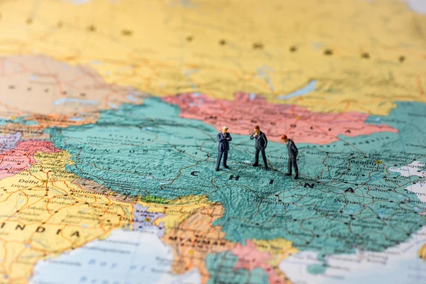 Miniature businesspeople on map of China