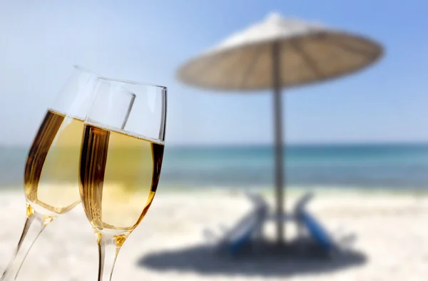 Glasses of champagne on beach
