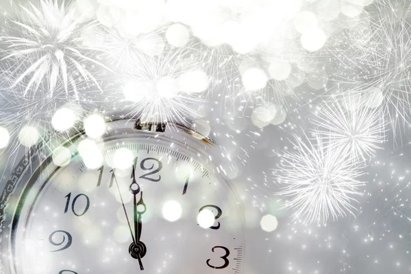 Old clock with fireworks and holiday lights