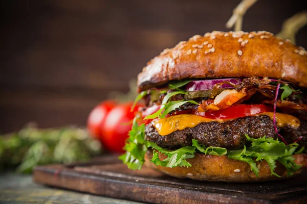 Tasty burgers on wooden table.