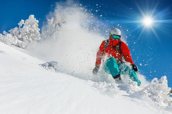 Skier skiing downhill in high mountains