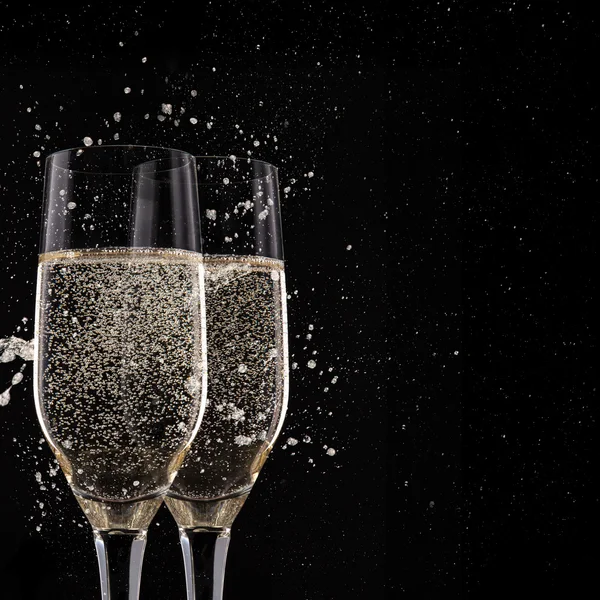 Champagne flutes on black background