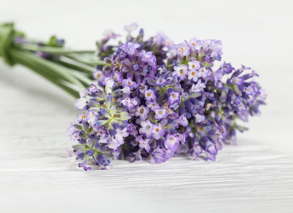 Wellness treatments with lavender flowers on wooden table.