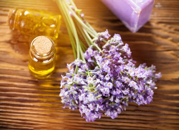 Wellness treatments with lavender flowers on wooden table.