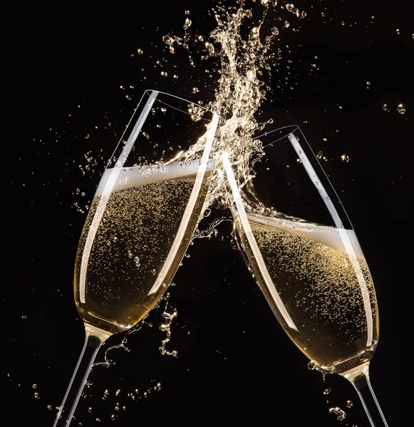 Glasses of champagne with splash, celebration theme.