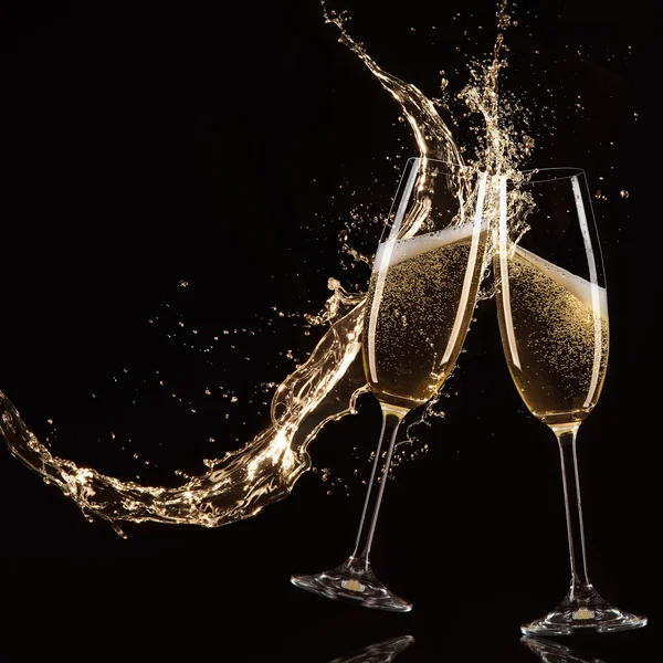 Glasses of champagne with splash, celebration theme.