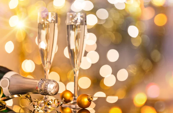 Glasses of champagne with bright gold background