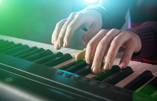 Mans hand playing piano.
