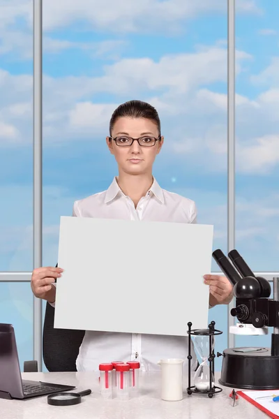 Female scientific researcher holding blank poster