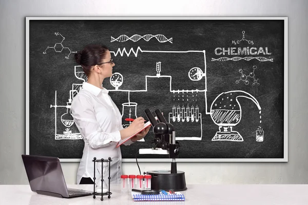 Female scientist looking on scheme chemical reaction
