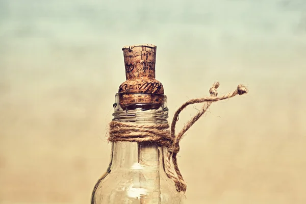Vintage glass bottle with a cork and rope. in such bottles used to put notes with messages and throw it into the sea. work of art handmade