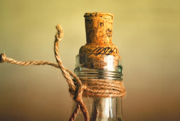 Vintage glass bottle with a cork and rope. in such bottles used to put notes with messages and throw it into the sea