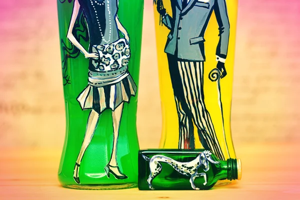 Stylized dog, woman and man. painting by hand on glass bottles. Decorative bottles, contemporary art