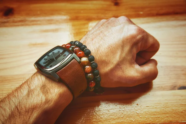 Fashion men, wrist watch, bracelet, volcanic stone bracelet stone agate. Male hand. Vintage style