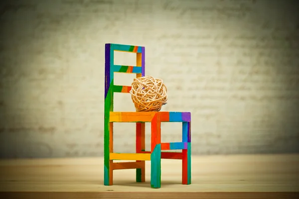 Decorative ball made of wood and toy chair. Contemporary Art