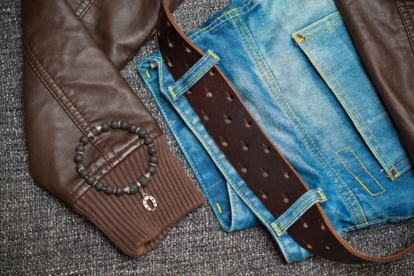 Fashion trend: jeans, leather jacket, leather belt, bracelet on the arm