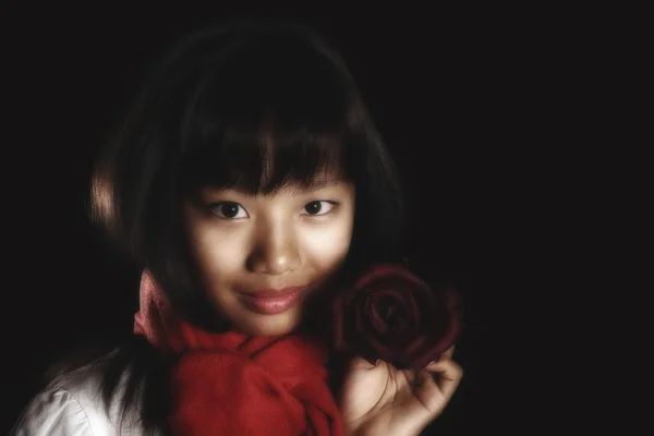 Asian beautiful girl with a smile holds a burgundy rose