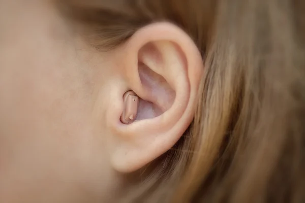 Hearing aid in your ear close-up. Modern equipment in medicine