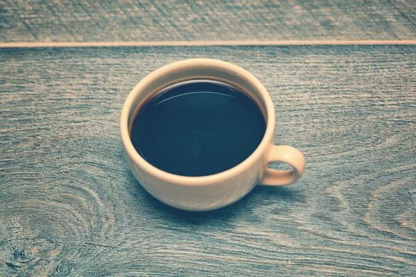 Cup of coffee on the old wooden table in rustic style