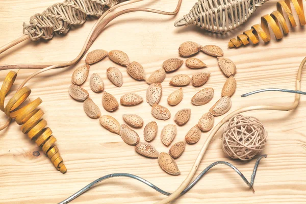 Heart of almonds - a symbol of love, Valentine\'s Day. Decorative background of natural art objects made of bamboo, wood, cane