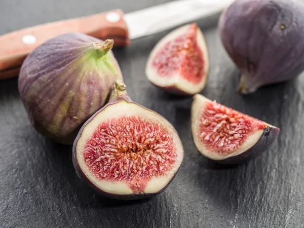Ripe fig fruits on the graphite cutting board.