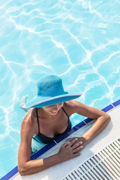 Woman in sun hat in the swimming pool. Top view.