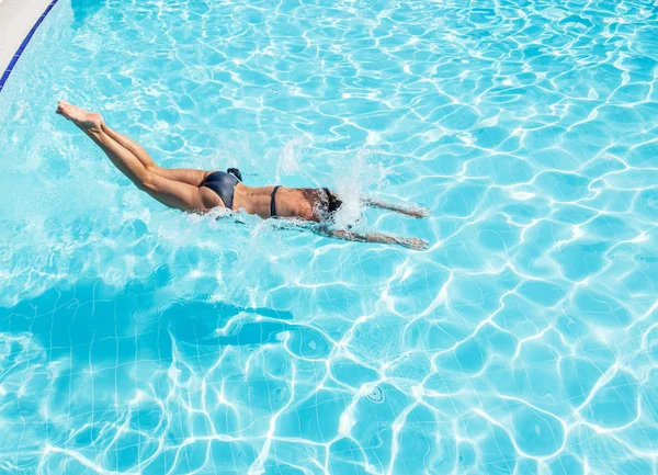 Woman jumping into the swimming pool.