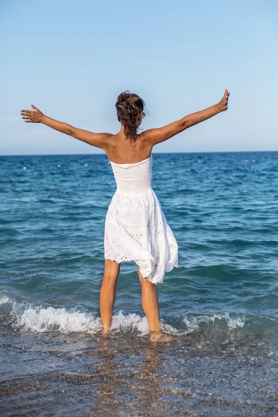 Happy woman stays in the sea water.