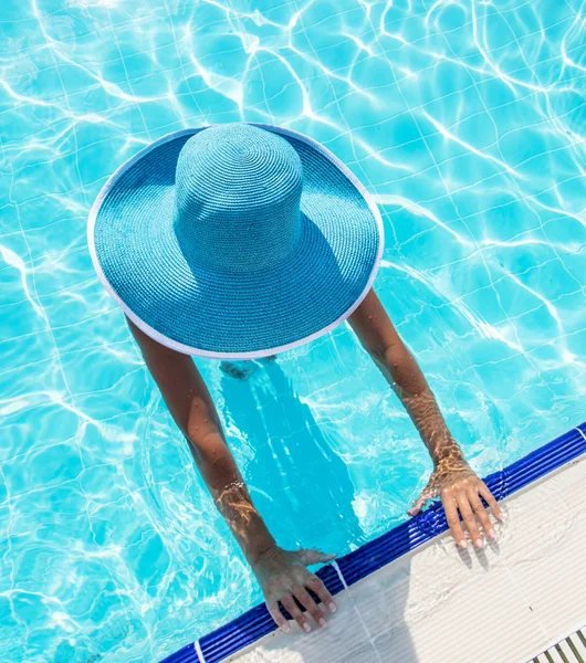 Woman in sun hat in the swimming pool. Top view.