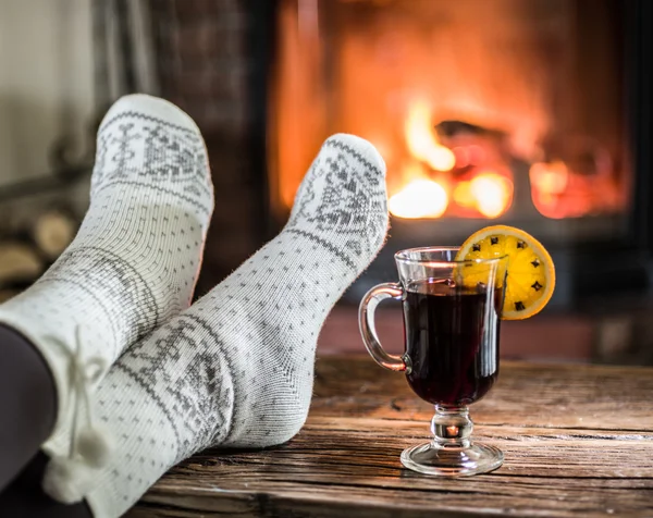 Warming and relaxing near fireplace with a cup of hot wine.