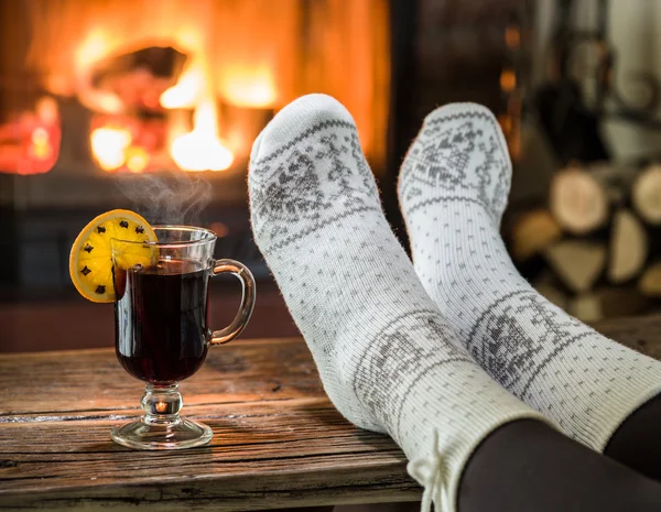 Warming and relaxing near fireplace with a cup of hot wine.