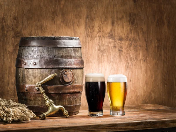 Glasses of  beer and ale barrel on the wooden table. Craft brewe