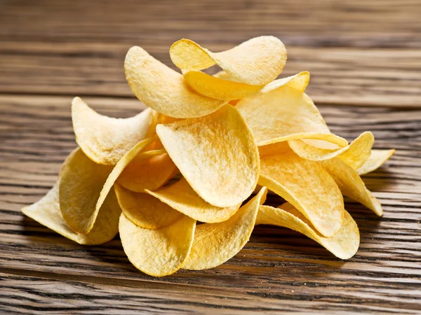 Potato chips on a wooden background.