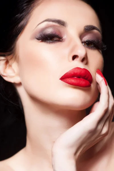 Fashion woman with sensual red lips and beautiful face - isolated on black. Skin care concept.