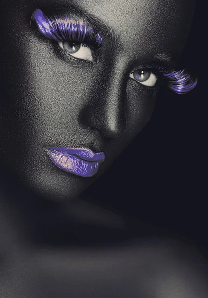 Creative and fashion portrait of a dark-skinned girl with color make-up