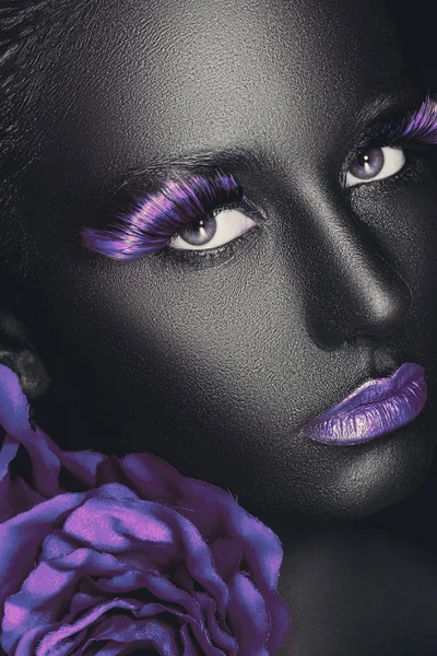 Creative and fashion portrait of a dark-skinned girl with color make-up