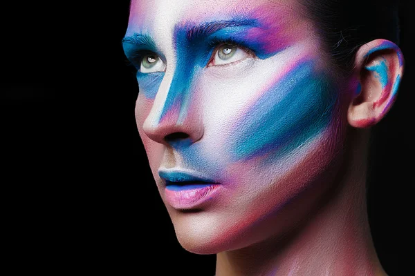 Beautiful fashion woman with bright color face art and body art. Paint on face. Creative portrait