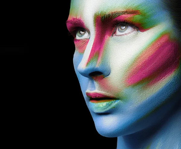 Beautiful fashion woman with bright color face art and body art. Paint on face. Creative portrait