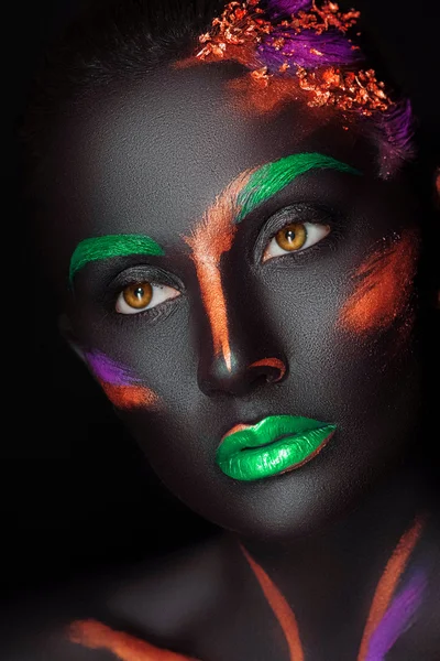 Close-up fashion portrait of a dark-skinned girl with color make-up