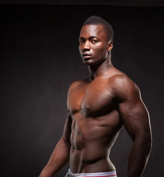 Beautiful and muscular black man in dark background