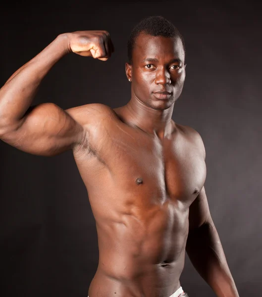 Beautiful and muscular black man in dark background