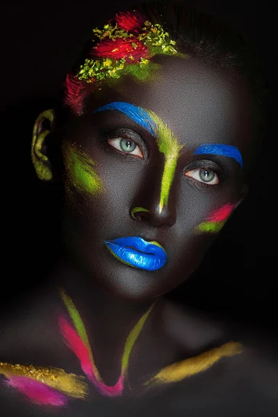 Close-up fashion portrait of a dark-skinned girl with color make-up