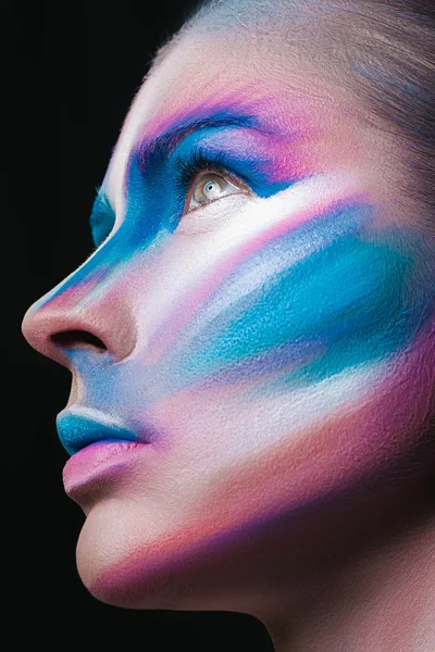 Beautiful fashion woman with bright color face art and body art. Paint on face. Creative portrait