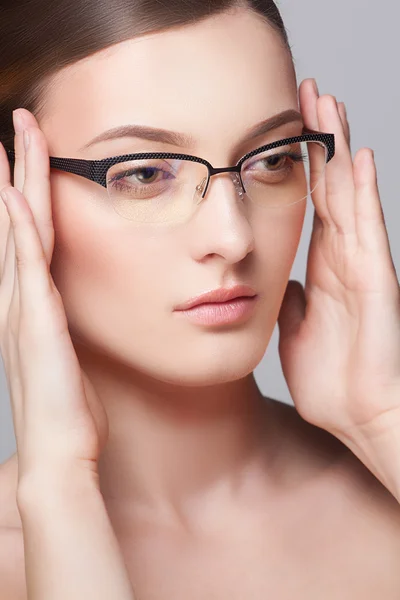 Close-up portrait of beautiful young woman in glasses