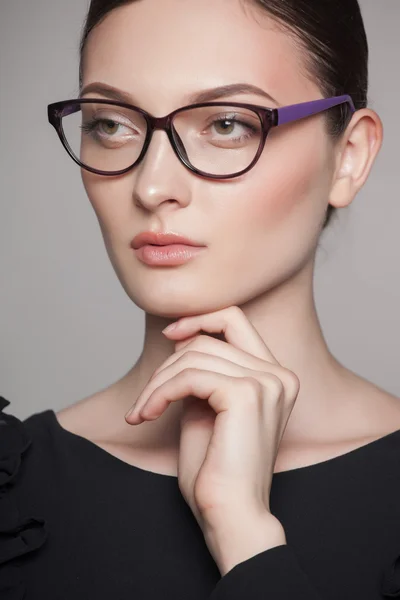 Close-up portrait of beautiful young woman in glasses