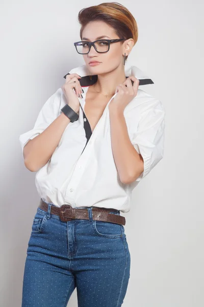 Cute young business woman with glasses and short hair, studio shoot